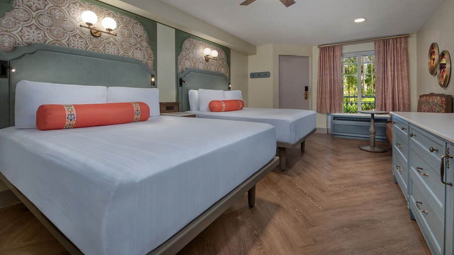 A Disney’s Port Orleans Resort hotel bedroom with a dresser, love seat, ceiling fan and 2 beds