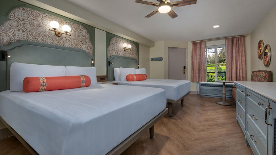 A Disney’s Port Orleans Resort hotel bedroom with a dresser, love seat, ceiling fan and 2 beds
