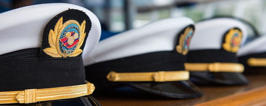 Captains' hats embroidered with the Disney Cruise Line logo sit in a row