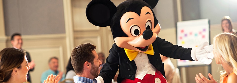 Mickey Mouse meeting attendees in a conference room