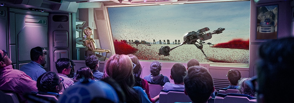 Les visiteurs à l’intérieur du simulateur de vol de l’attraction Star Tours avec vidéo numérique 3D, R2D2 et C3PO
