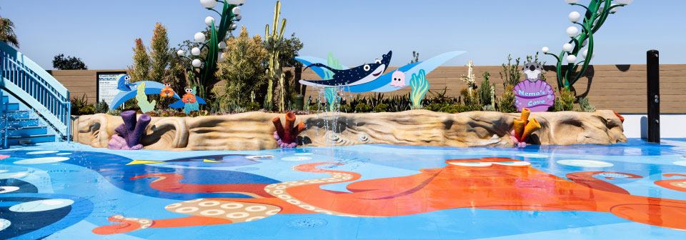 A children’s splash area, decorated with coral, characters from Finding Nemo and a sign that says Nemo’s Cove