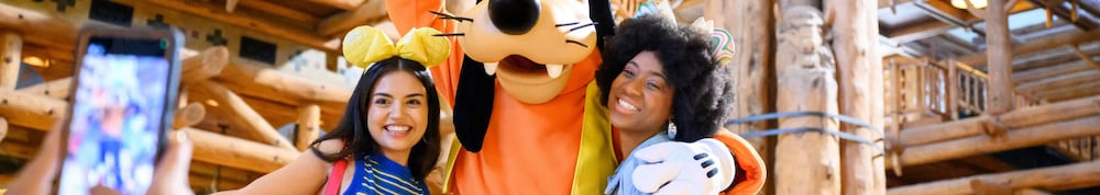 Goofy and 2 Guests posing for a photo at Disneyโs Wilderness Lodge Goofy and 2 Guests posing for a photo at Disneyโs Wilderness Lodge