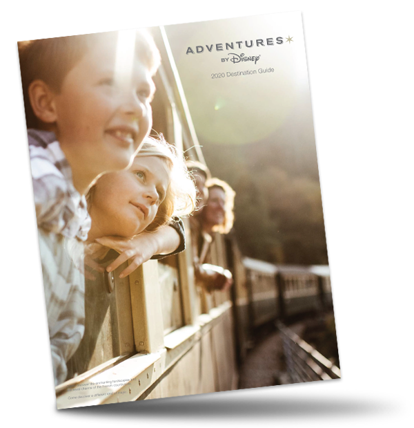 The Adventures by Disney 2020 Brochure logo on an image of a boy, a girl and their parents looking out at the passing scenery from their windows on a train