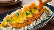 Sugar cane shrimp skewer served over steamed rice and topped with coconut lime sauce
