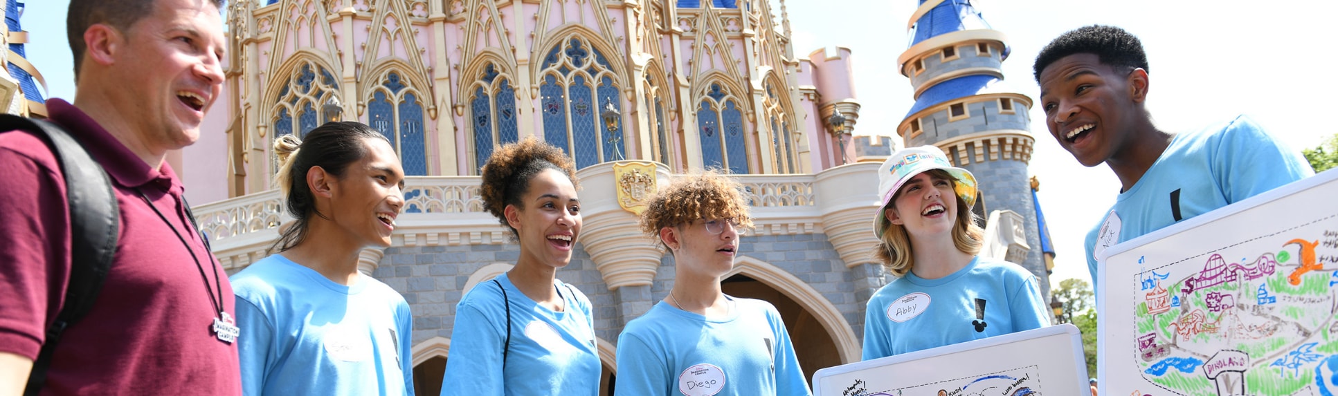 Disney Imagination Campus students examine hand drawn maps outside of Cinderella Castle 