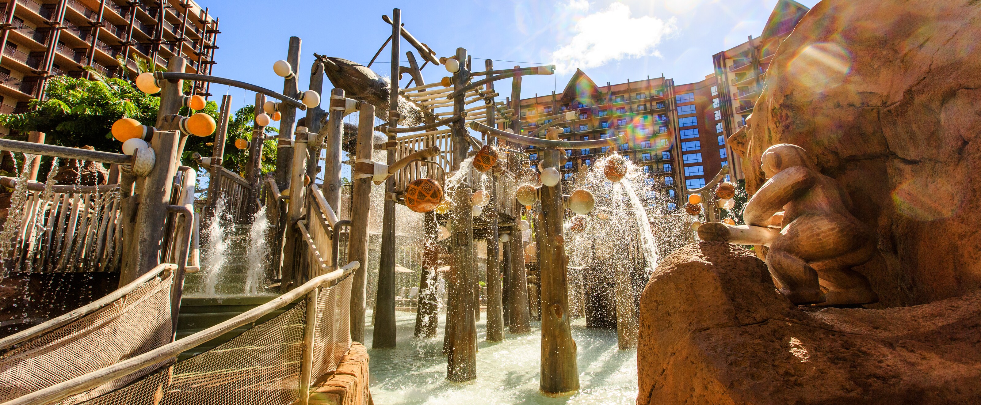 Water spills down from the Menehune Bridge as the Resort's rooms and suites tower in the background