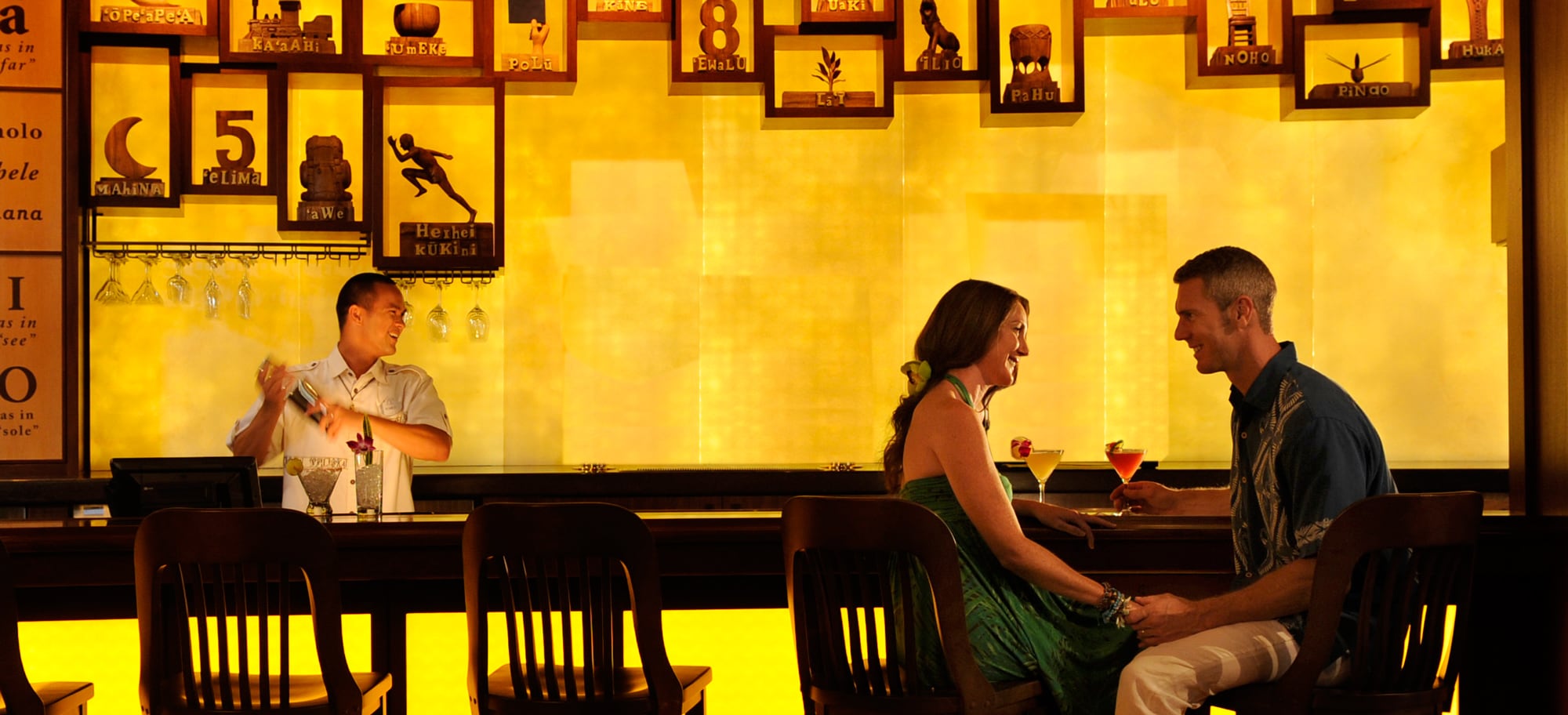 Two girlfriends enjoy cocktails and appetizers at an outdoor table as the sun sets