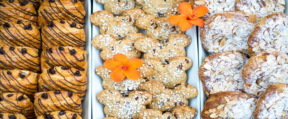 Three trays of pastries holding croissants and scones shaped like a Mickey Mouse head