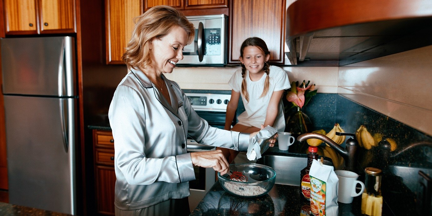A mother and daughter cooking in the kitchen of their Villa
