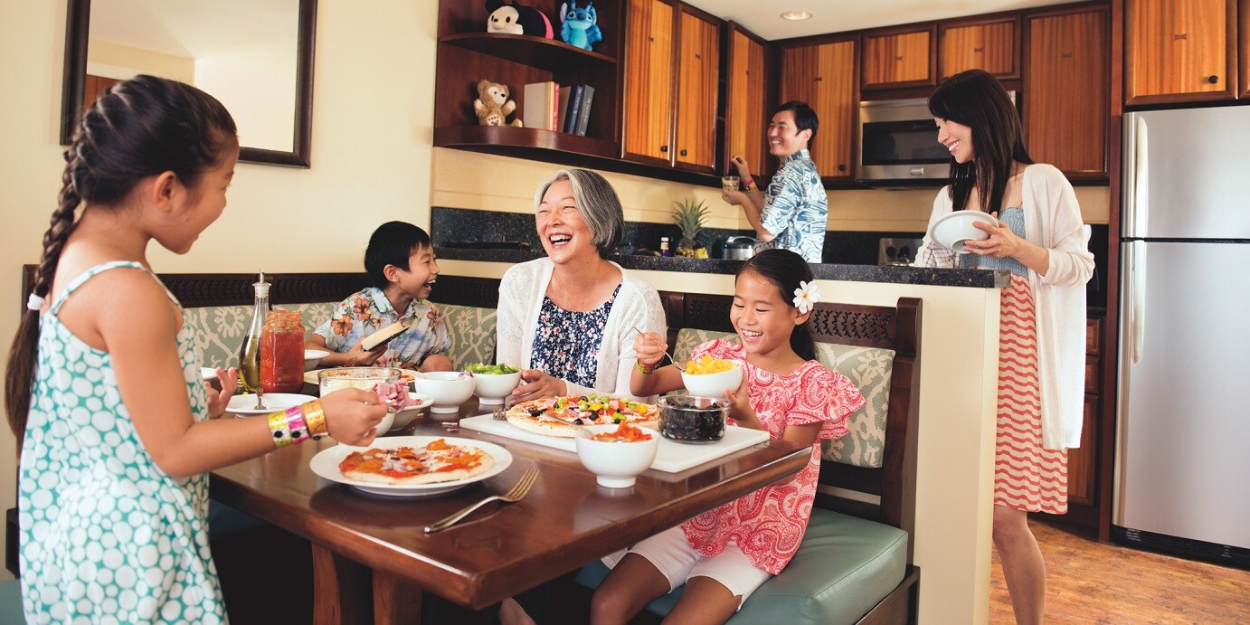 A family in the kitchen and dining area of their Villa