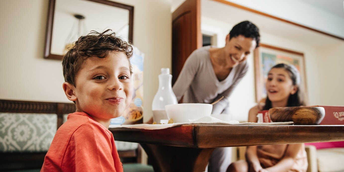 A boy, girl and their mother at the kitchen table of their Villa