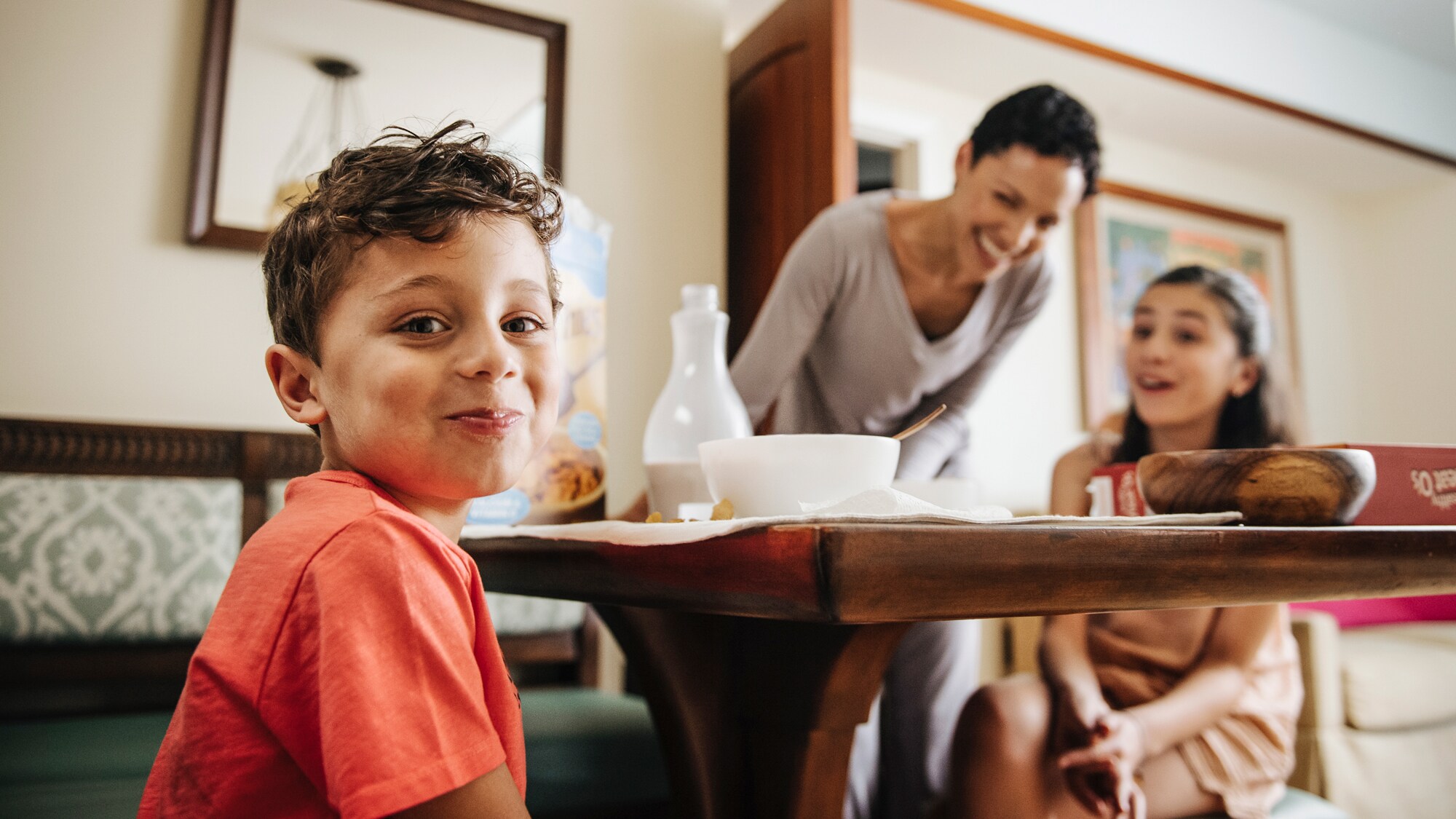 A boy, girl and their mother at the kitchen table of their Villa