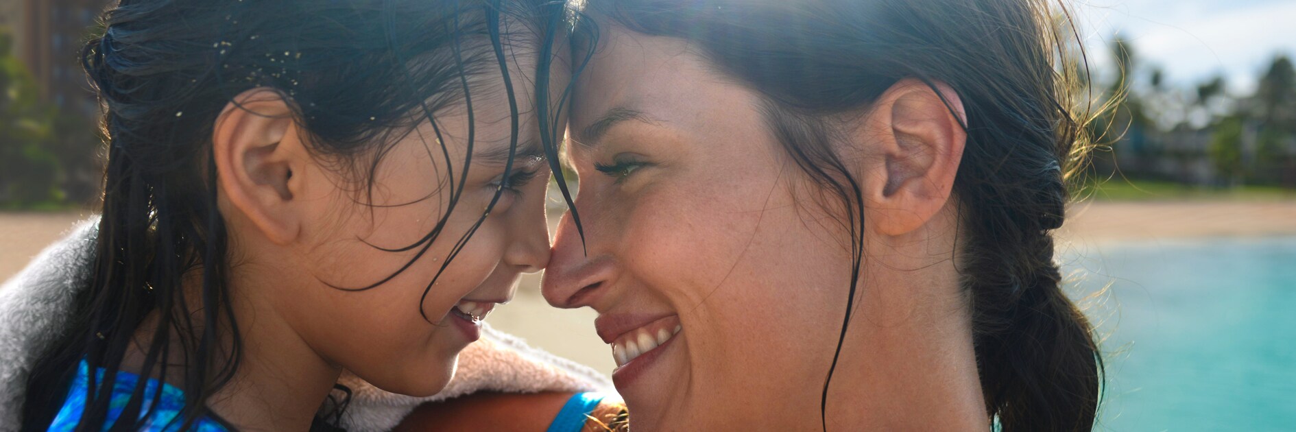 A mother and daughter are all smiles while touching noses