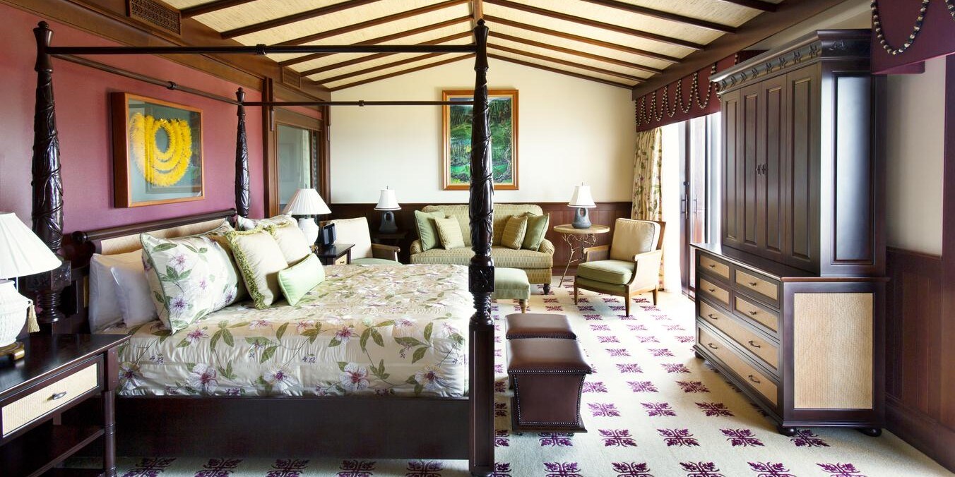 A bedroom furnished with a bed, sofa, chairs and entertainment center