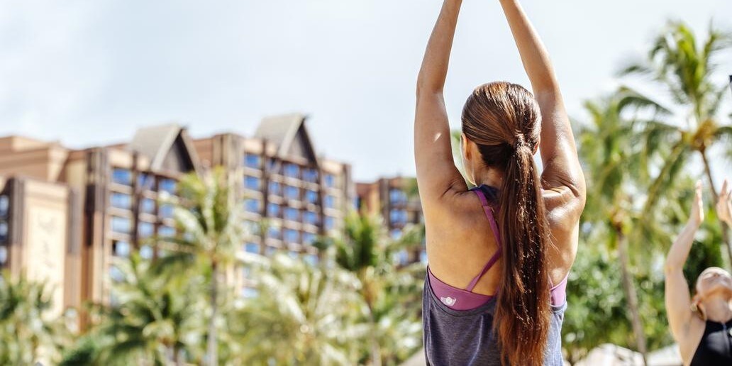 A woman raising her arms to the sky in a yoga pose