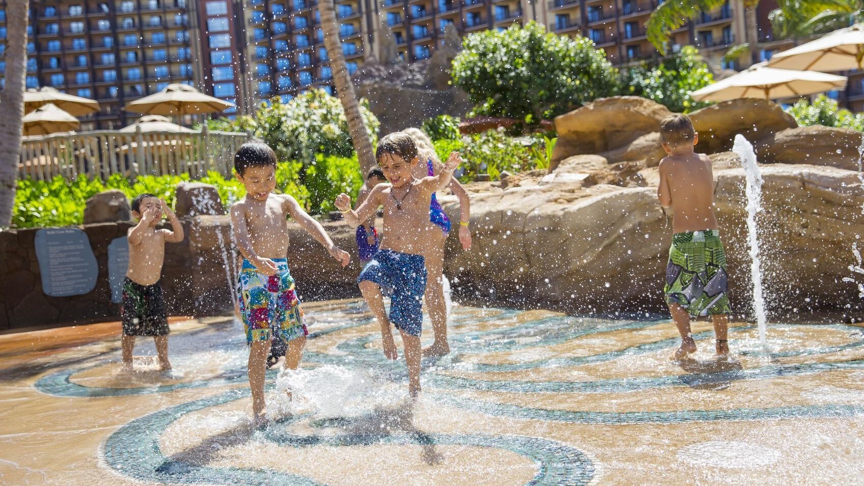 Several children splashing one another in a water playground
