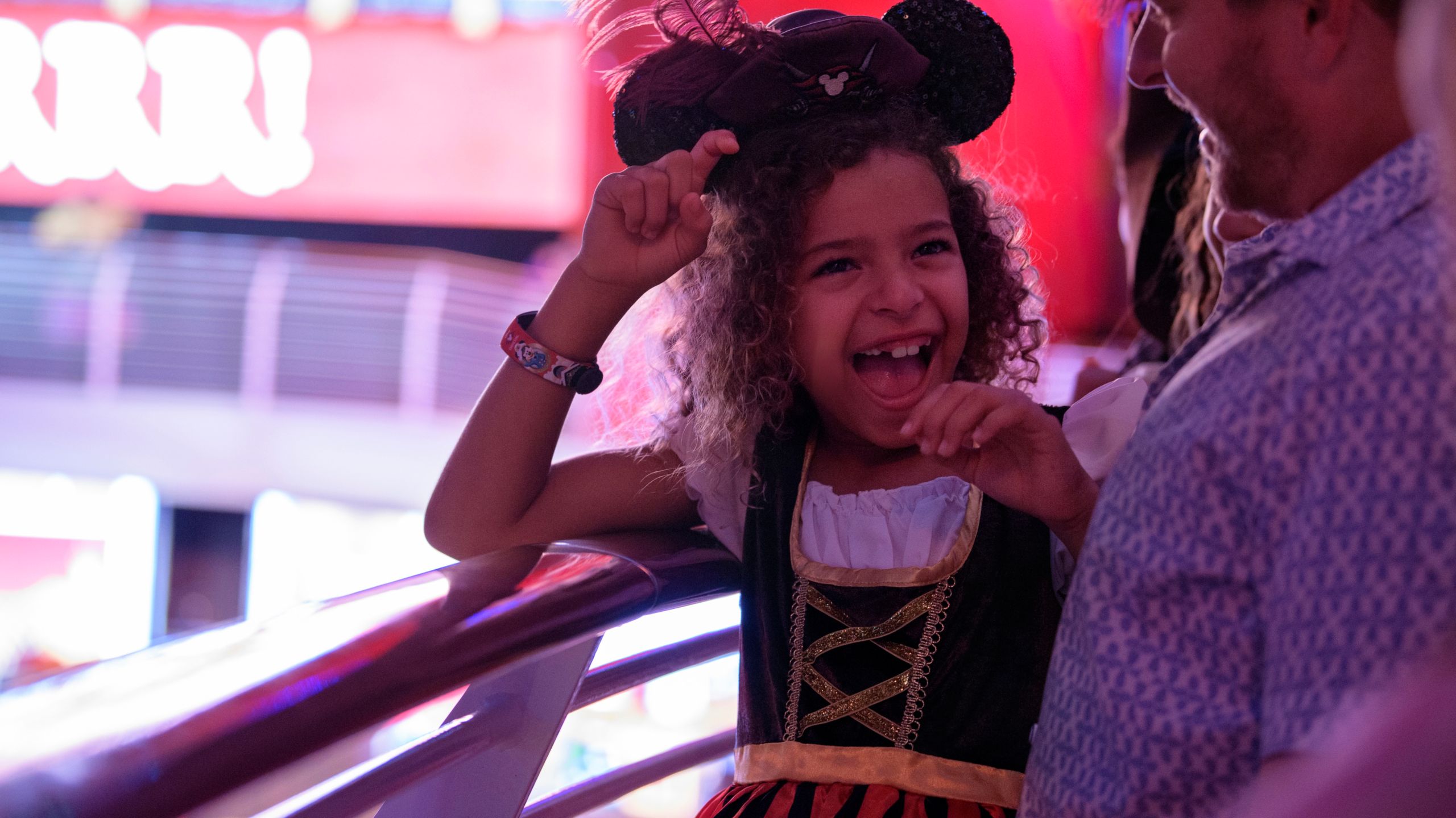 A girl smiling while wearing a Mickey Mouse Pirates of the Caribbean themed Ear Headband