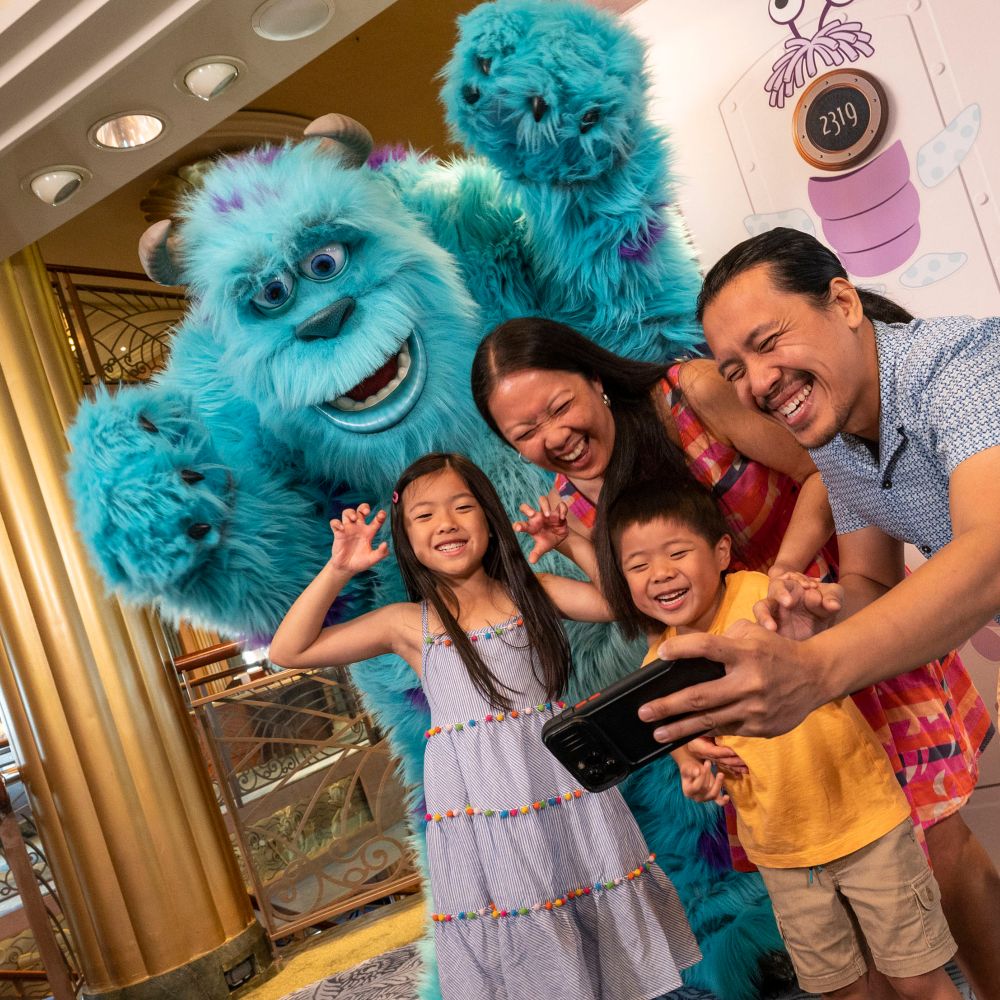 A family taking a selfie with Sulley from the Pixar film Monsters Inc