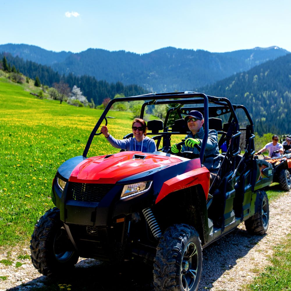 Guests driving all terrain vehicles along a path through Alaskan mountains