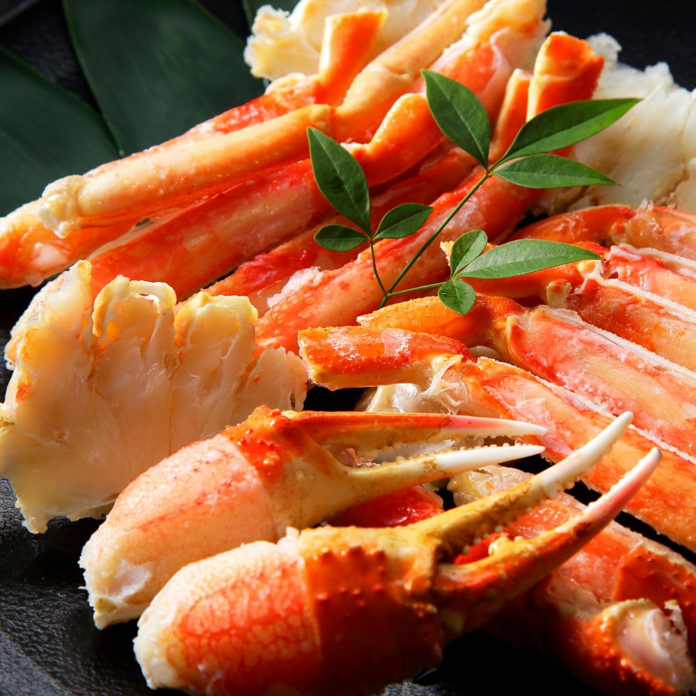 A plate of cooked and disassembled crab garnished with fresh herbs