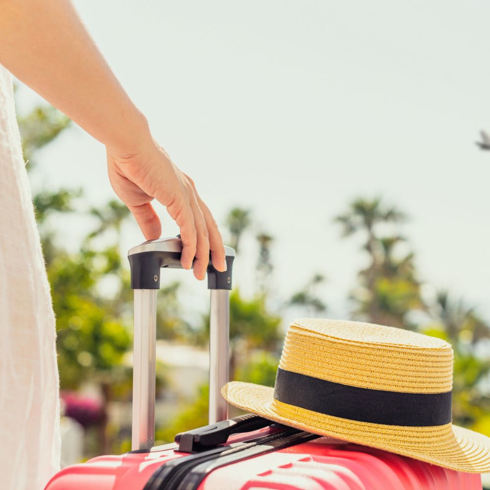 A Guest holding the handle of their rolling suitcase at Fort Lauderdale Hollywood International Airport