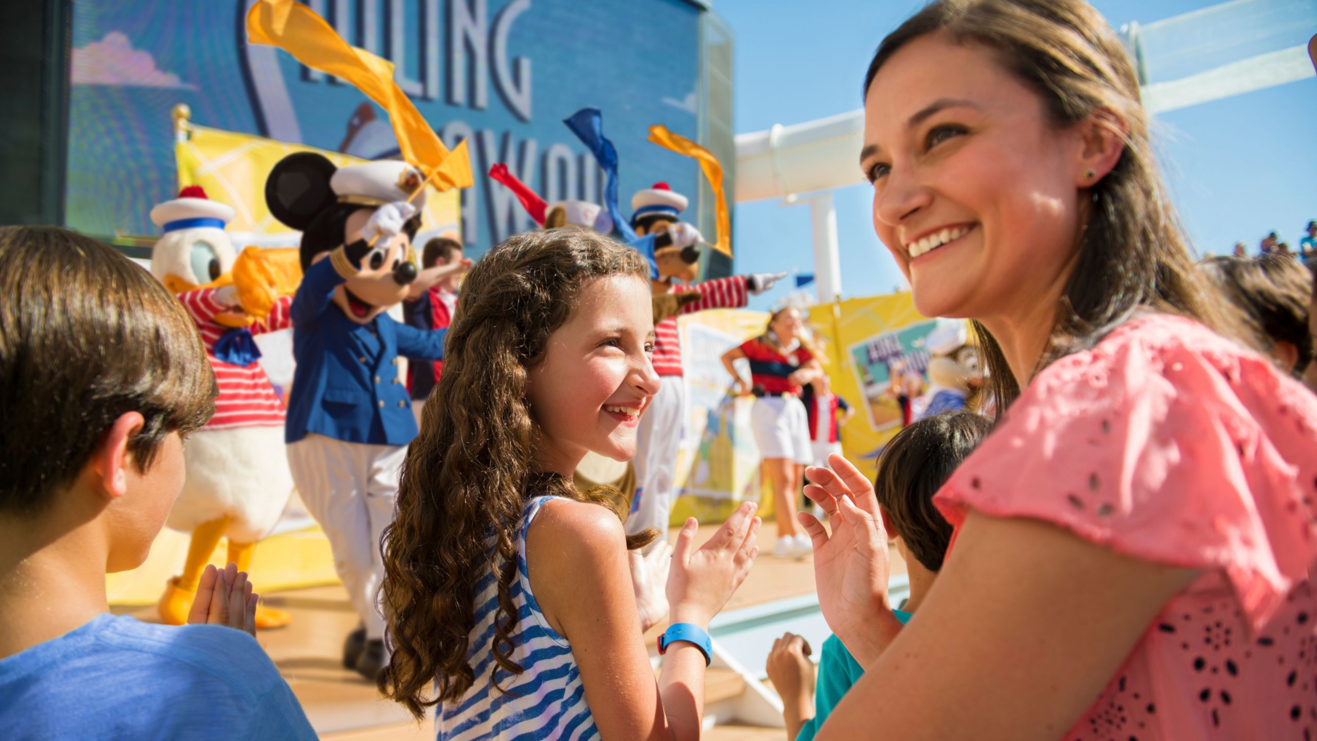 Huéspedes sonriendo mientras observan Sailing Away Deck Party