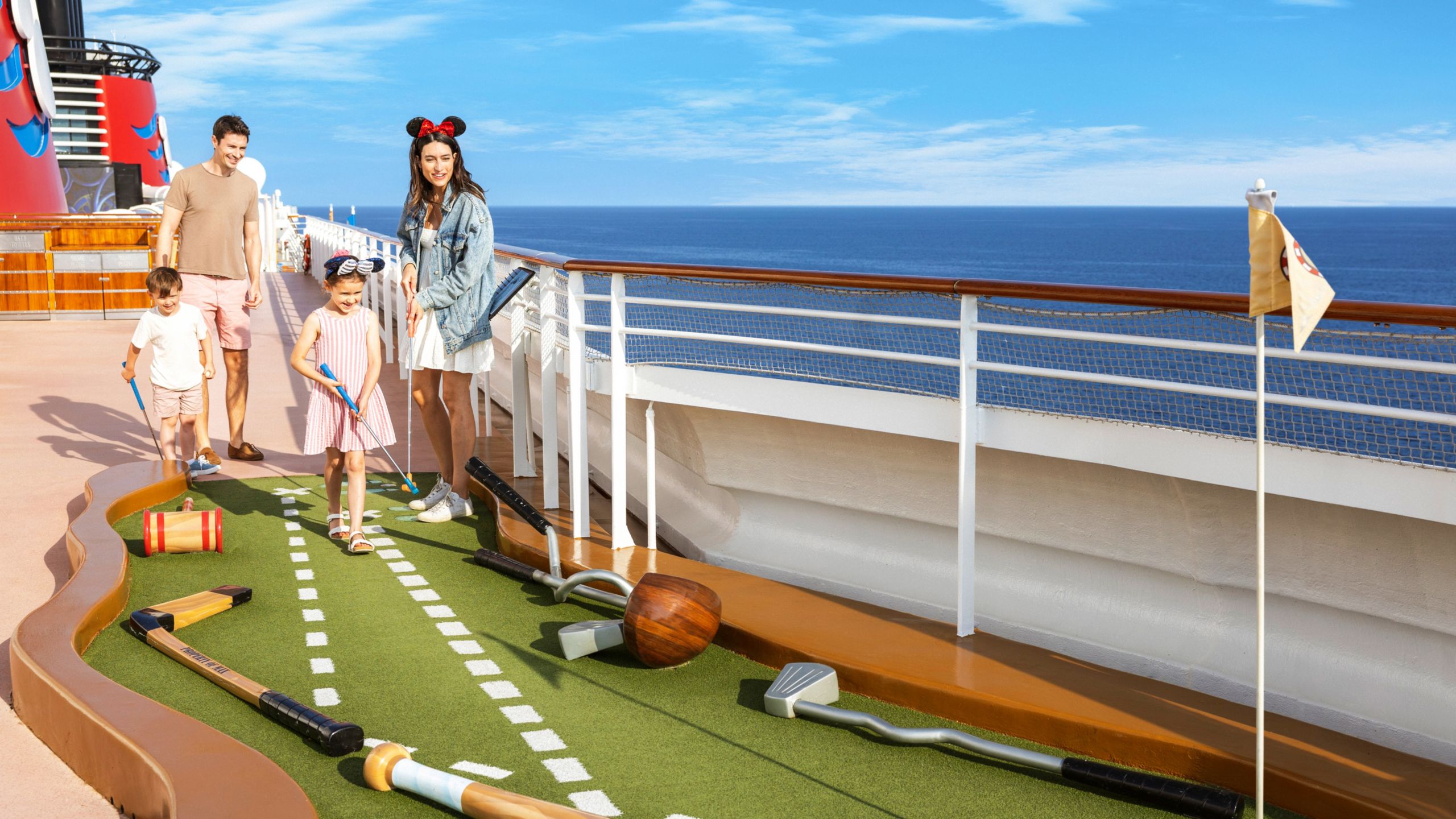 A family playing miniature golf on the deck of the Disney Dream
