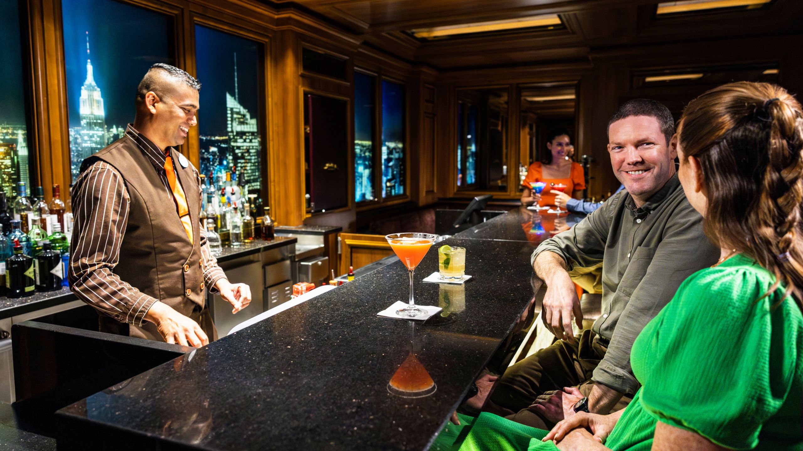 Un barman hablando con una pareja en el bar Skyline