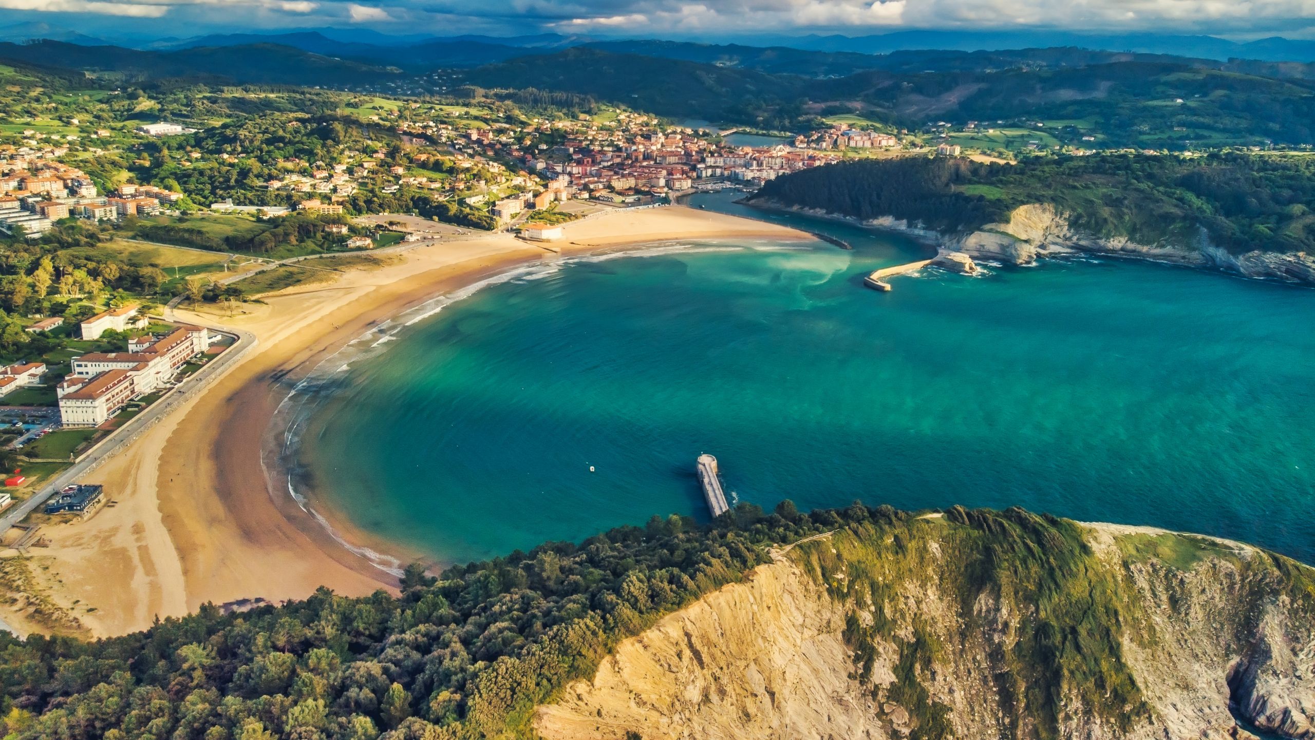 An aerial view of Playa de Gorliz featuring a seashell shaped shoreline in northern Spain