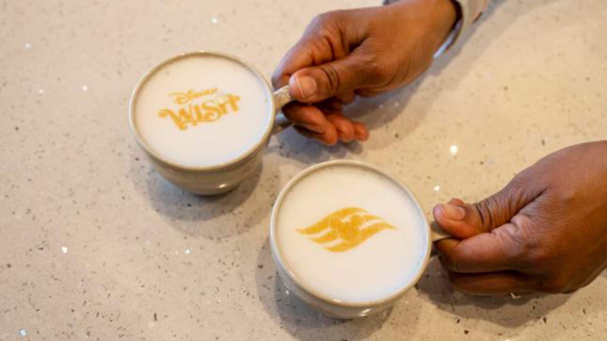 Two cups of coffee with foam designs of text that says Disney Wish and the Disney Cruise Line logo