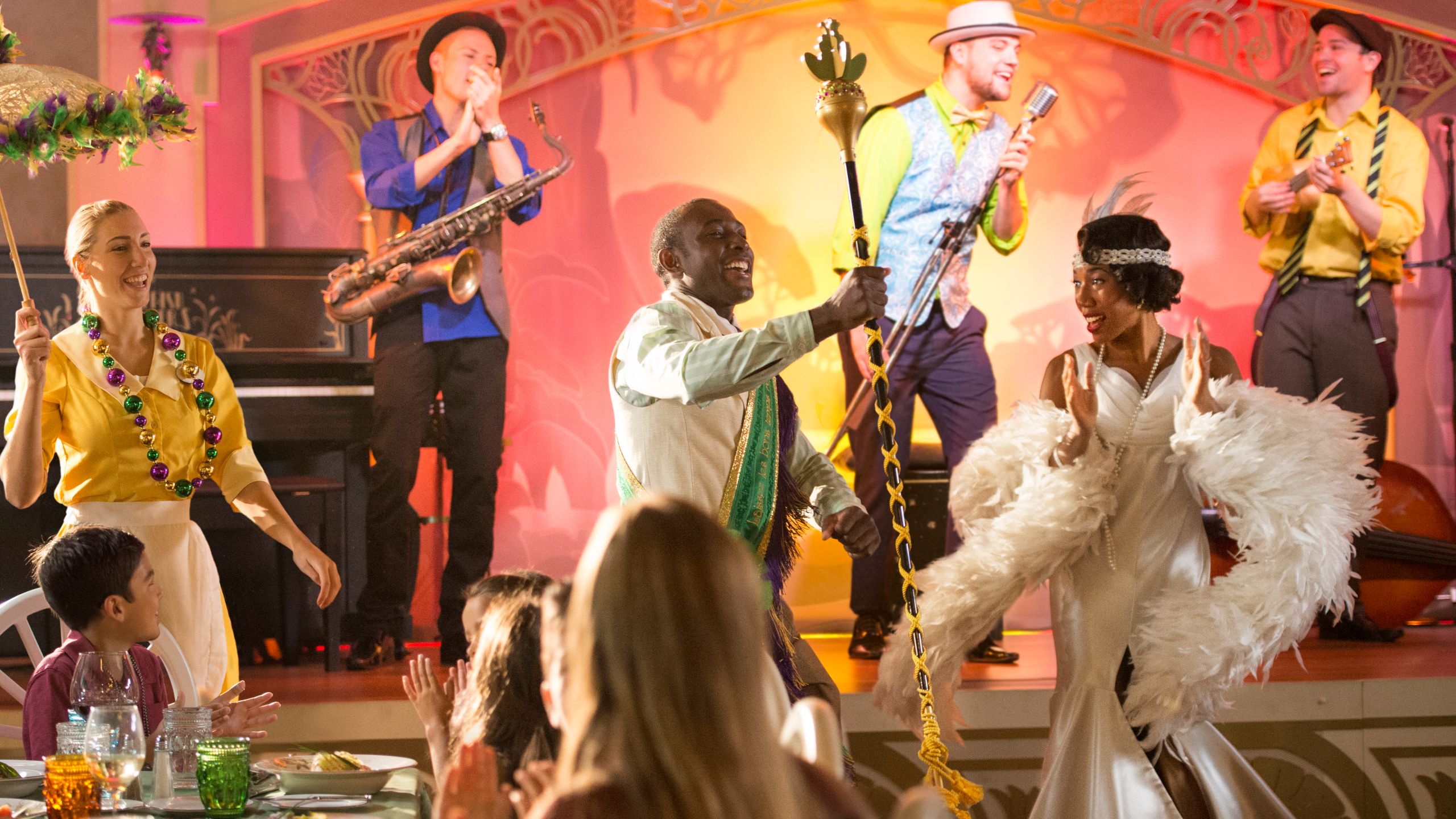 Tiana, along with 2 Cast Members, perform with a band on stage