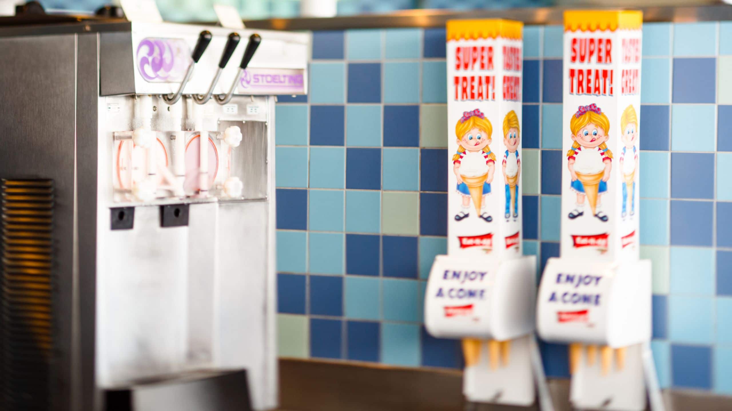 A soft serve ice cream machine and 2 ice cream cone dispensers from Wheezy's Freezies