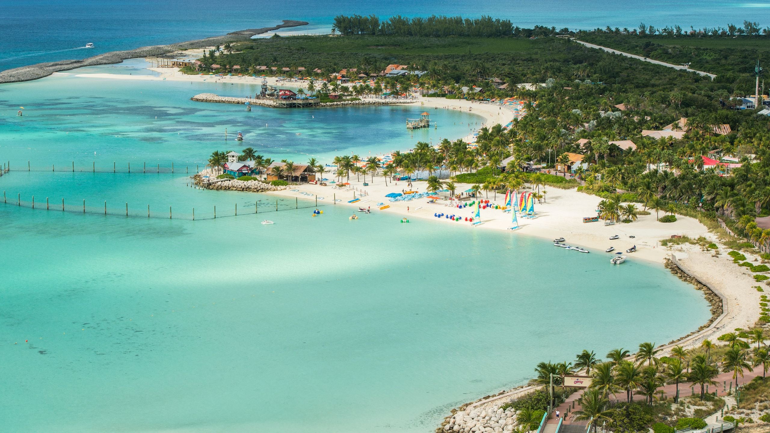 A panoramic view of Disney Castaway Cay featuring calm waters, sandy beaches and beach equipment along the shore