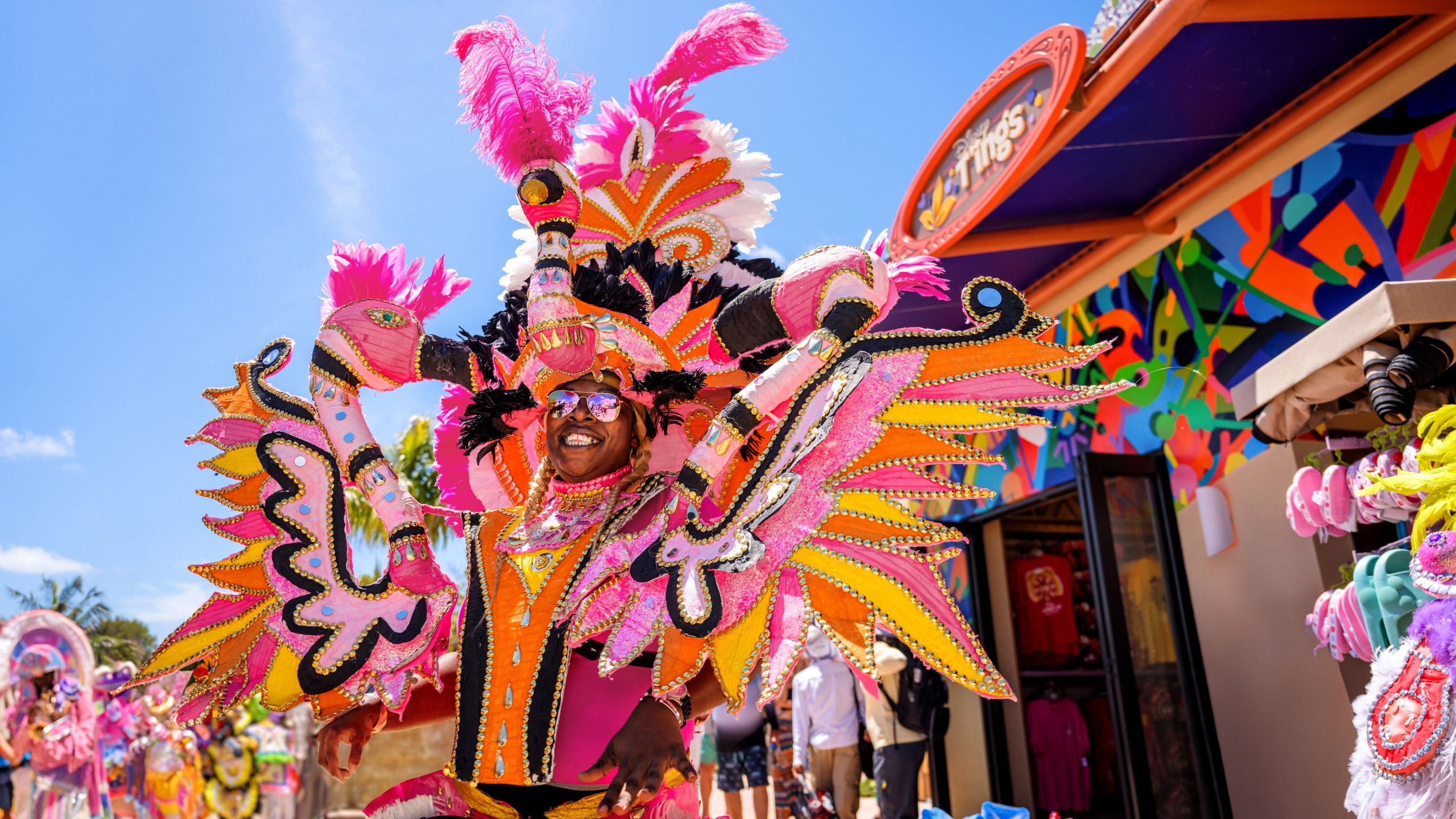 Un hombre sonriendo en un desfile vestido con ropa festiva bahameña