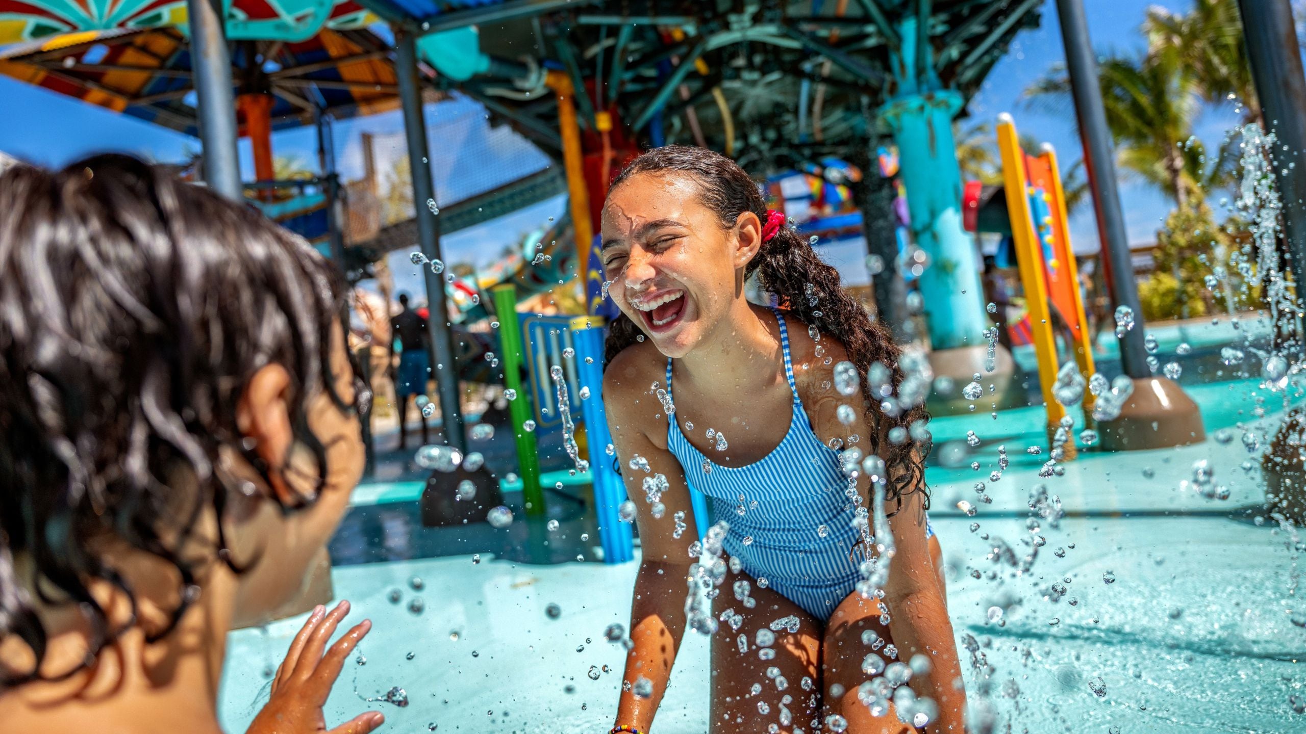 Una niña ríe mientras juega en el agua en el área de juegos acuáticos Rush Out Gush de Disney Lookout Cay en Lighthouse Point