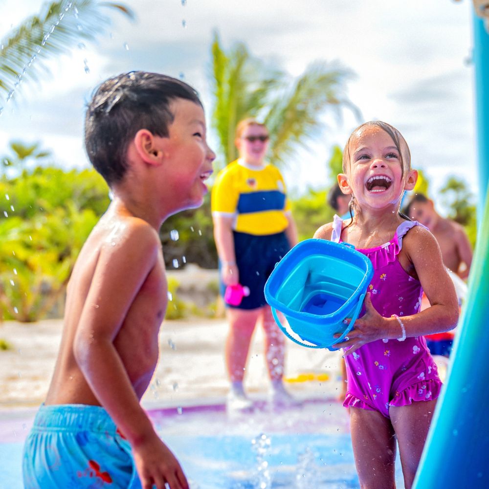 Dos niños jugando en el agua en Sebastian's Cove, una zona de chapoteo en Disney Lookout Cay en Lighthouse Point