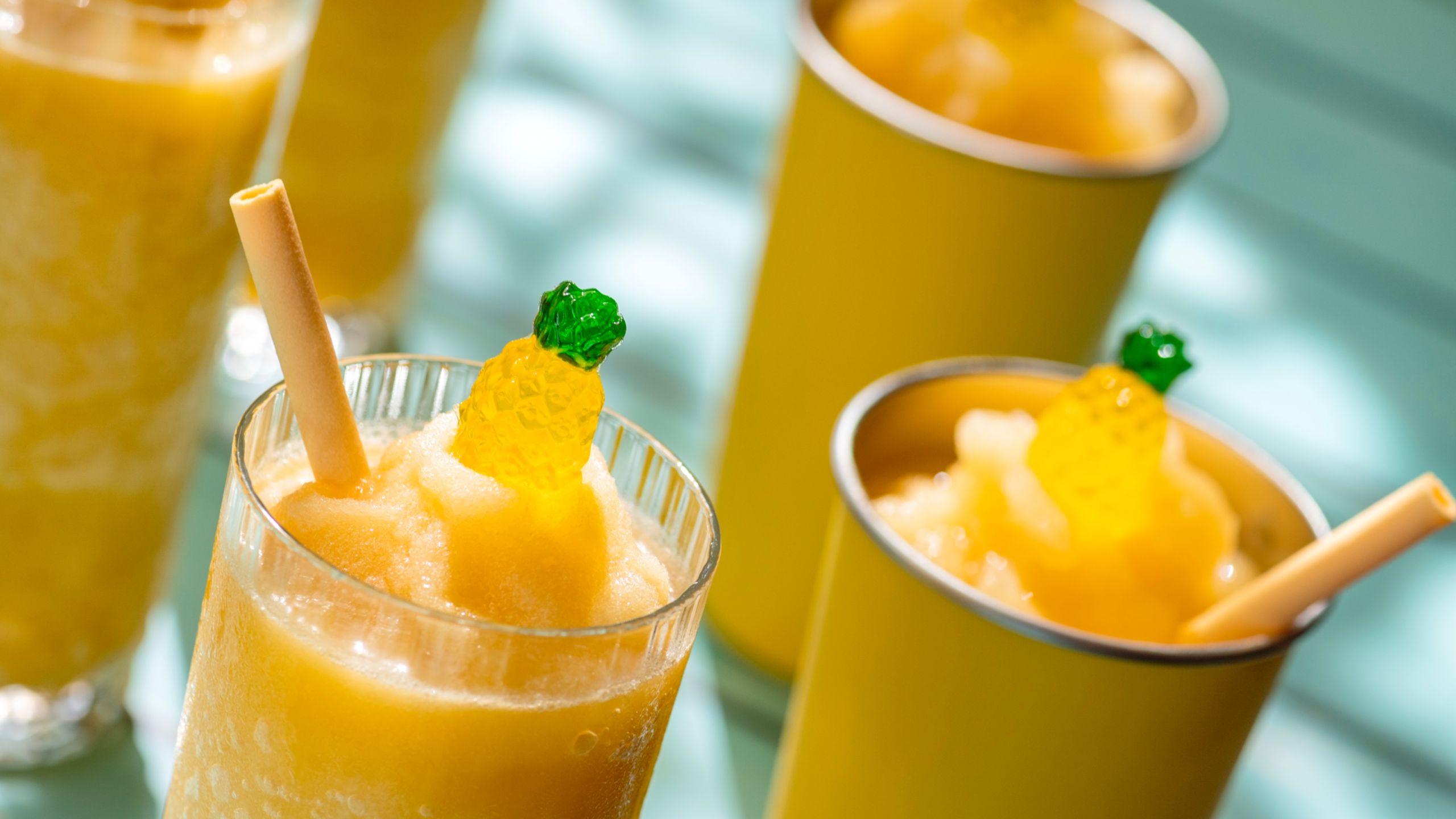 Batidos congelados en copas y vasos cubiertos con una deliciosa golosina con forma de piña 