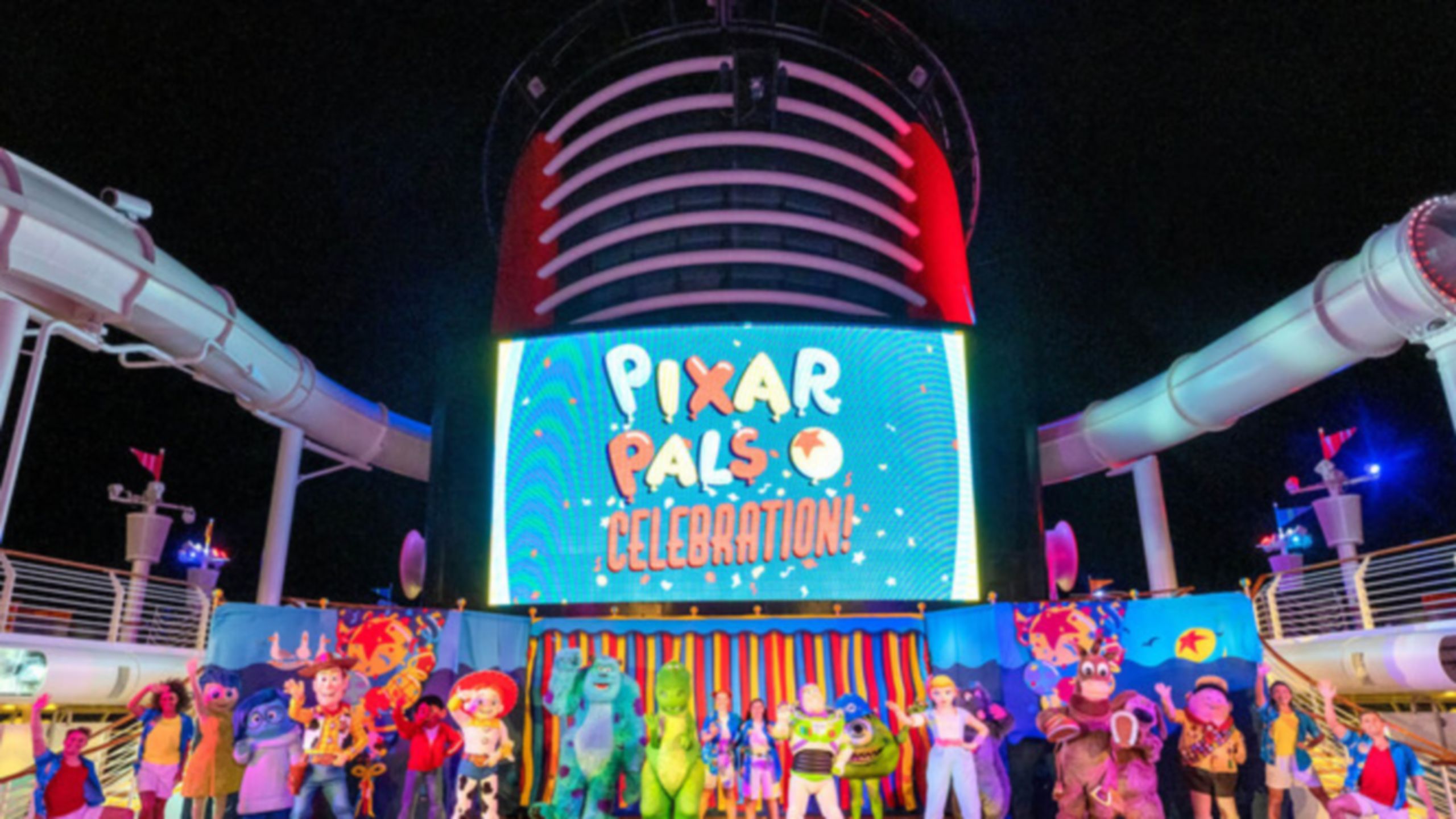 Pixar Characters waving on the deck of a Disney cruise ship with a screen that reads ‘Pixar Pals Celebration‘