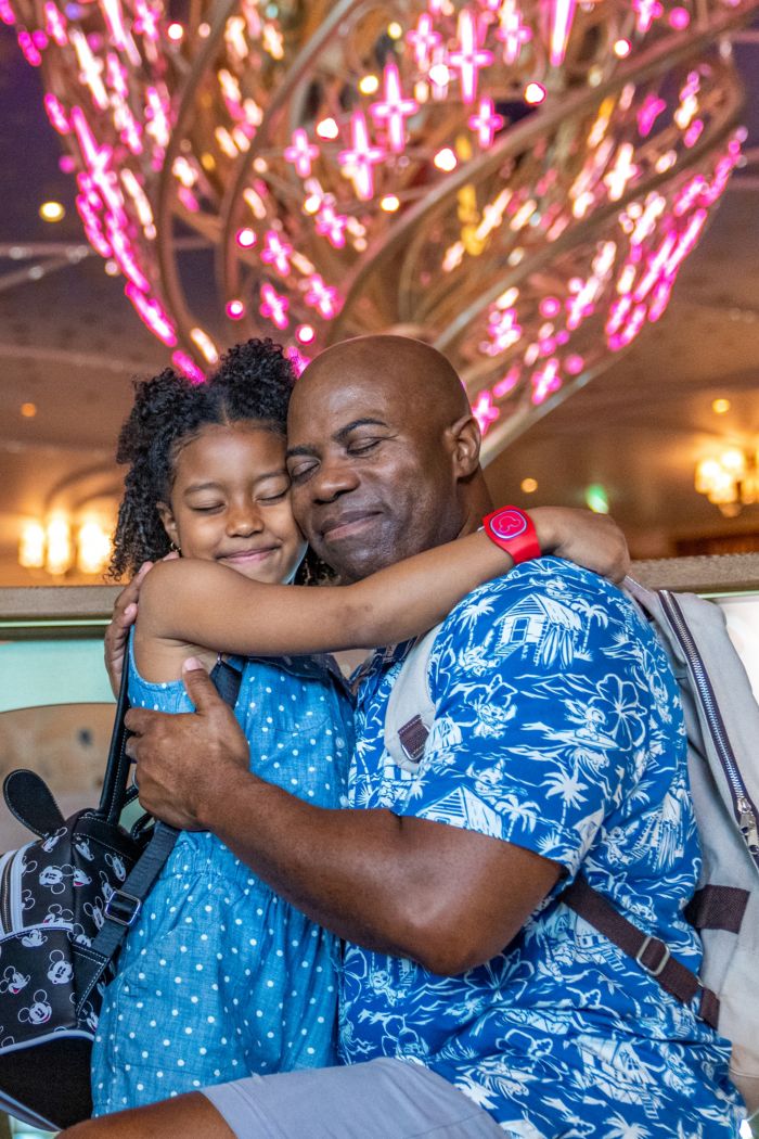 A father hugs his daughter as they embrace cheek to cheek