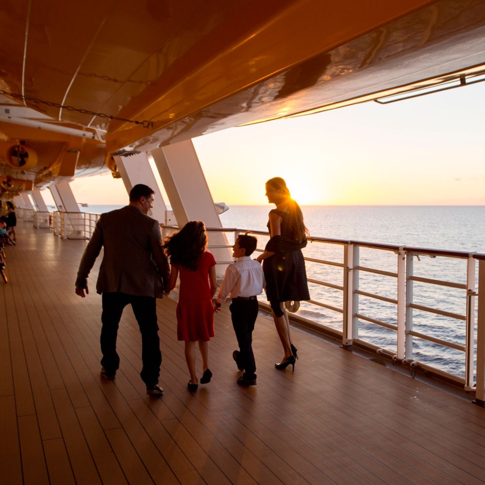 Uma família caminhando no deck de um navio da Disney Cruise Line