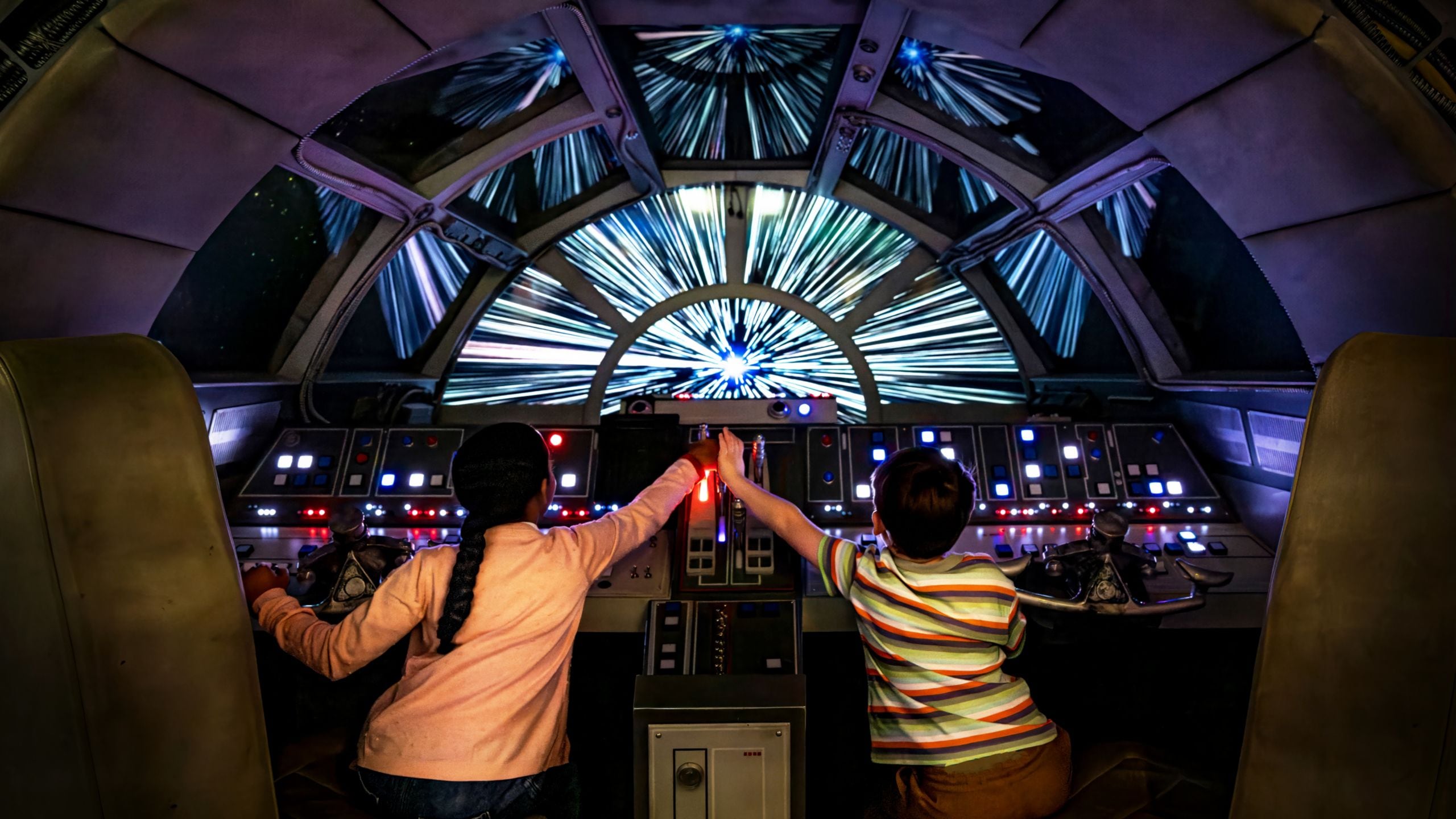 Duas crianças sentadas na cabine da Millennium Falcon a bordo do navio Disney Dream