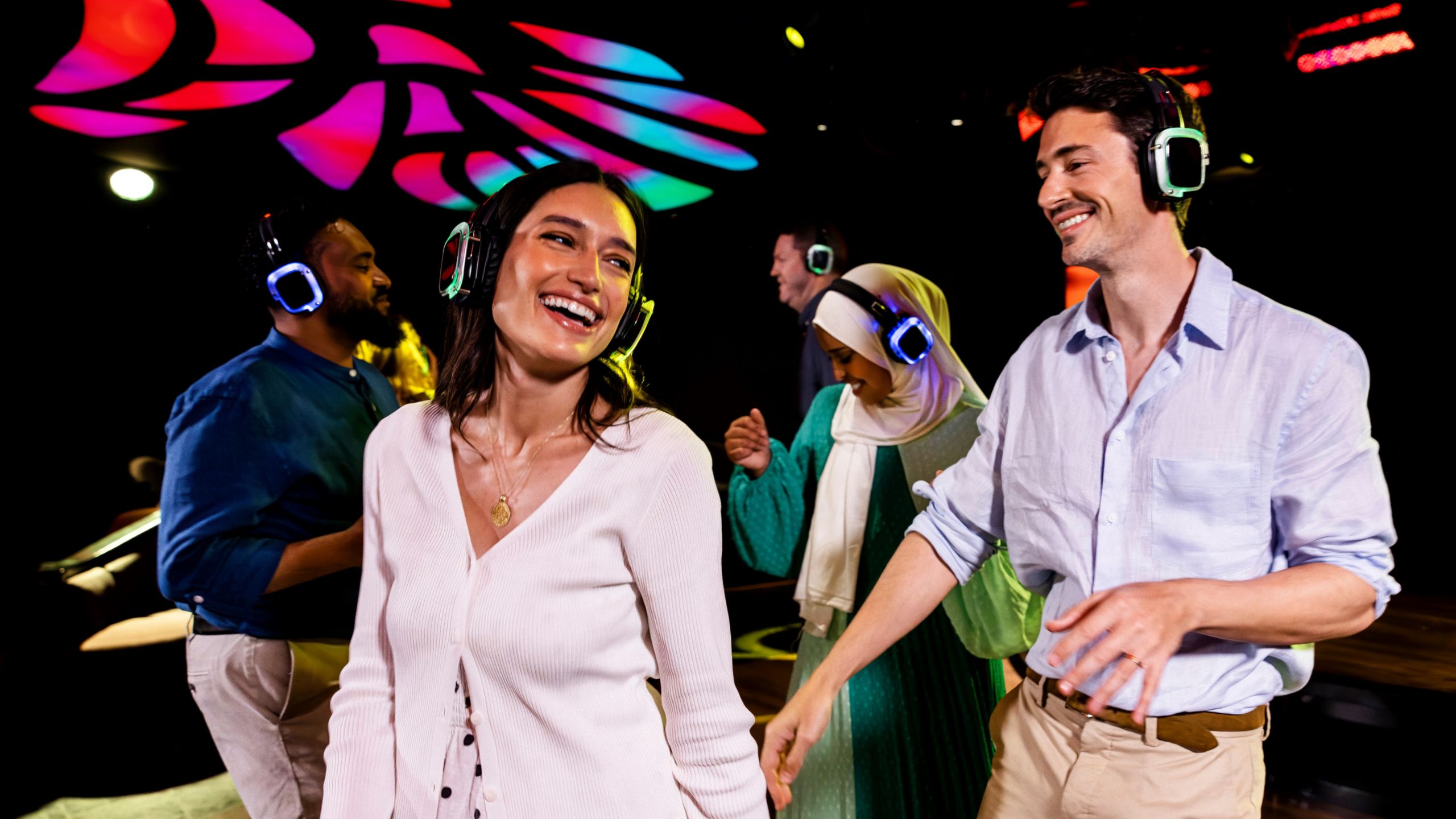 Hóspedes dançando enquanto usam fones de ouvido em uma festa silenciosa com DJ no clube noturno Evolution