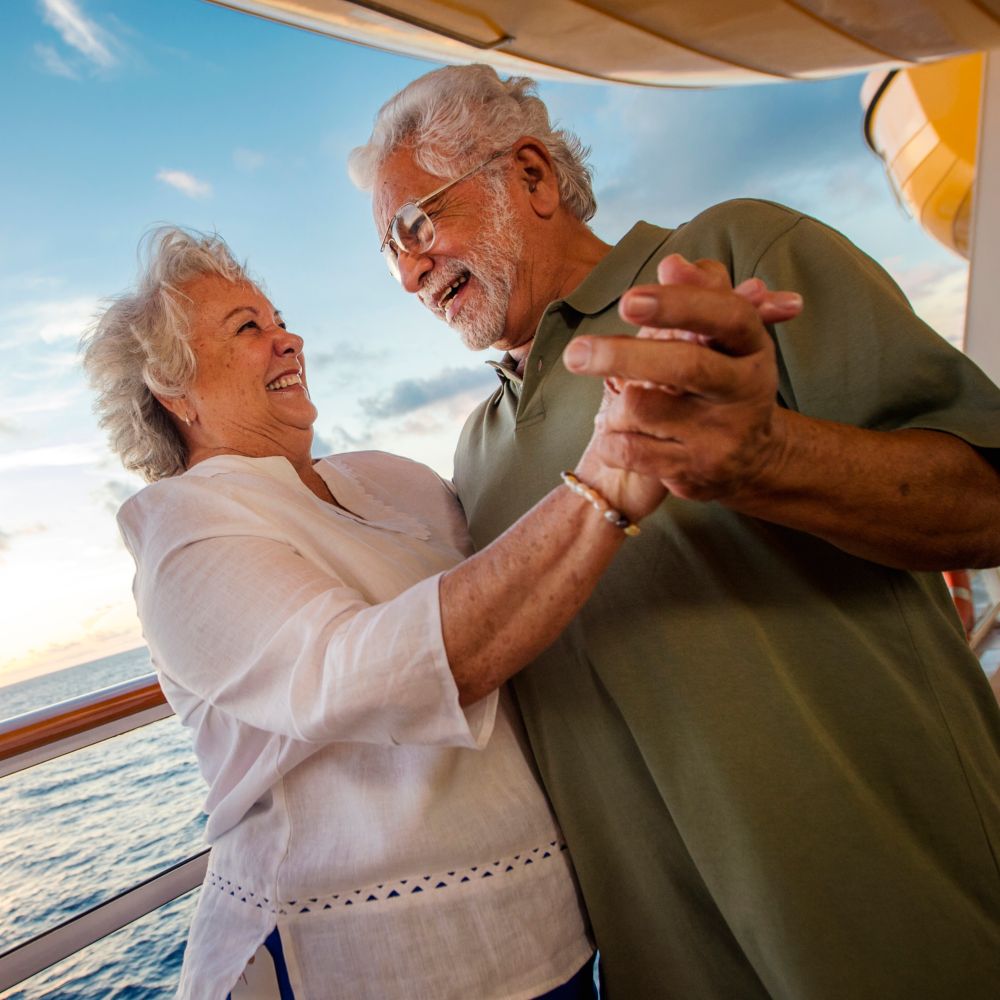 Um casal de mãos dadas e dançando a bordo do navio de cruzeiro Disney Fantasy