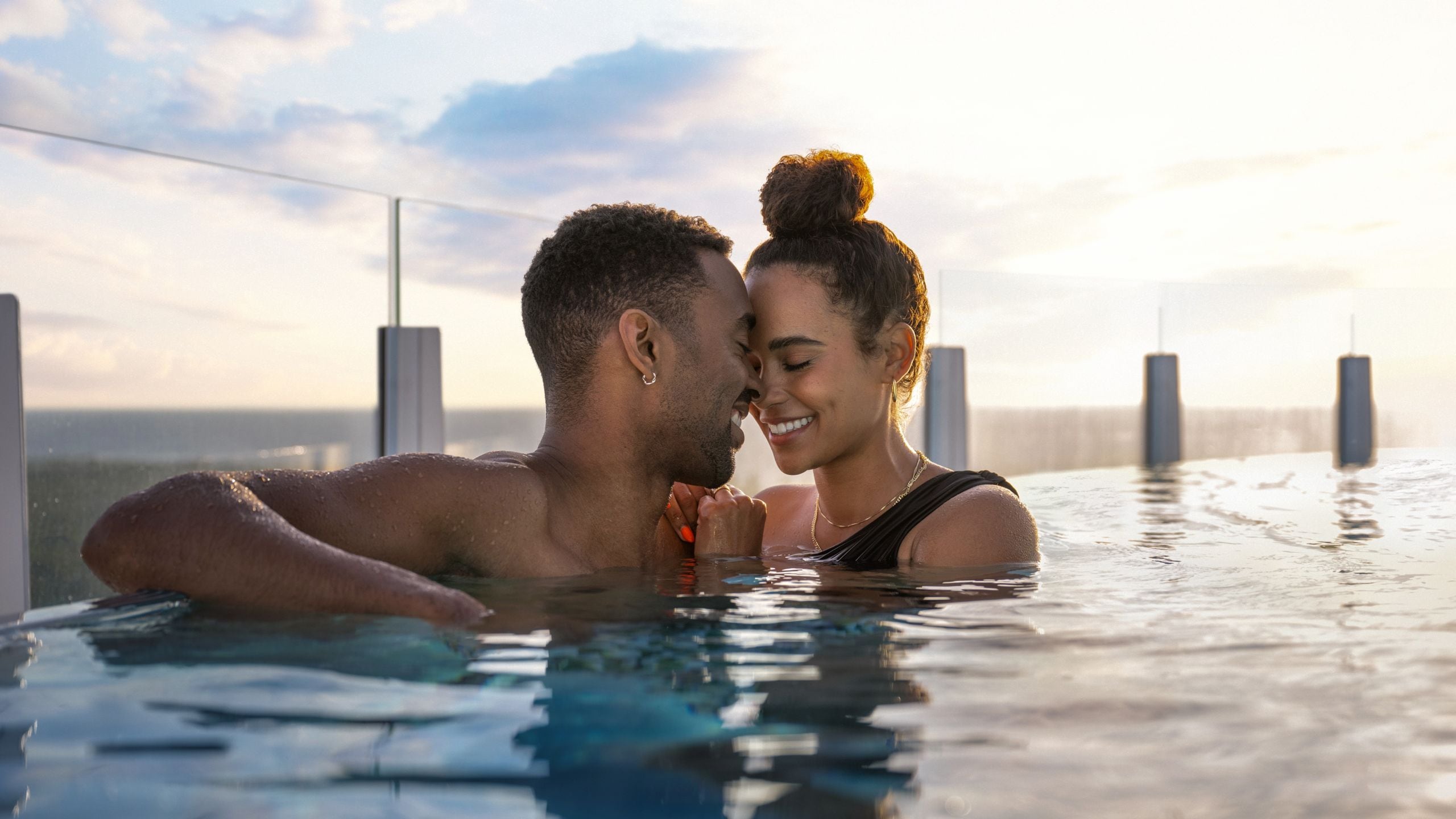 A couple embracing in the Quiet Cove Pool on board the Disney Destiny ship
