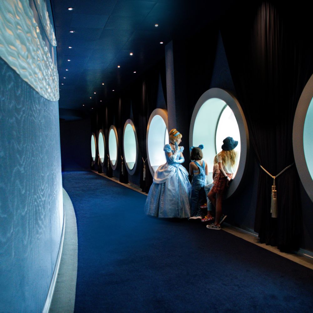 Cinderela olha pelas janelas redondas com crianças a bordo de um navio da Disney Cruise Line