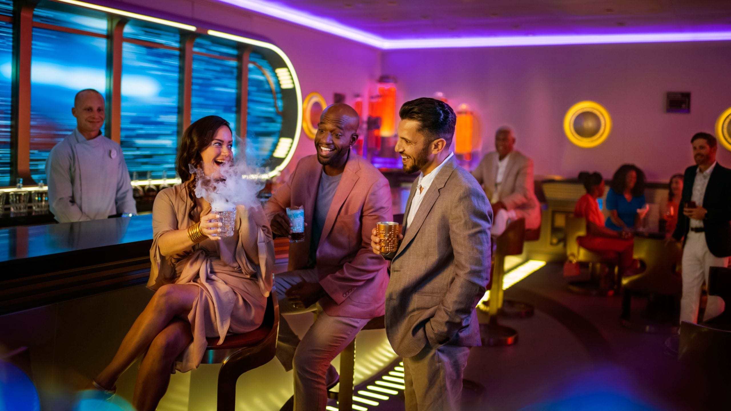 Um grupo de pessoas ri enquanto saboreia coquetéis no Star Wars Hyperspace Lounge