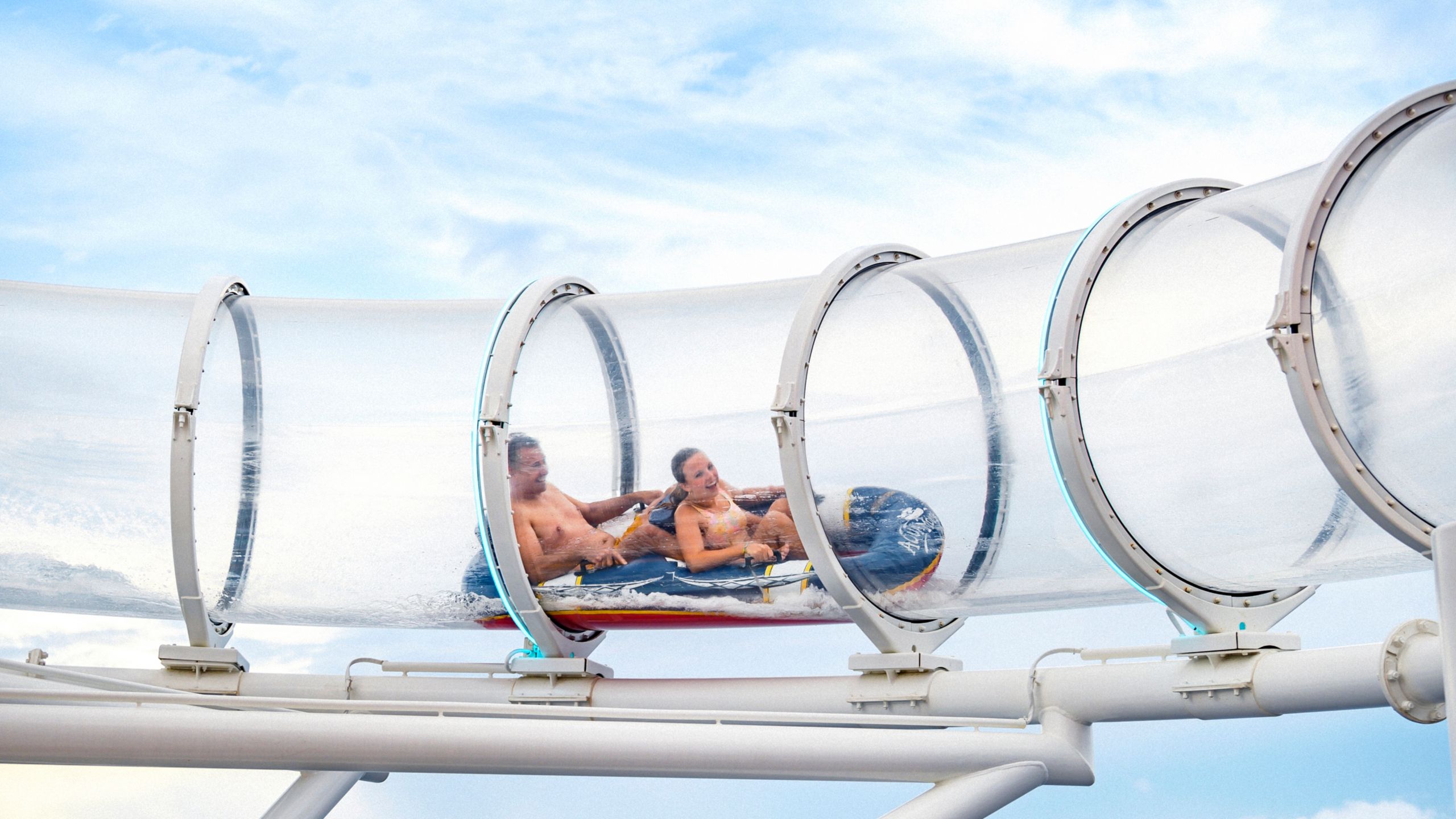 Duas pessoas se aventurando no toboágua Aqua Mouse a bordo do navio de cruzeiro Disney Wish