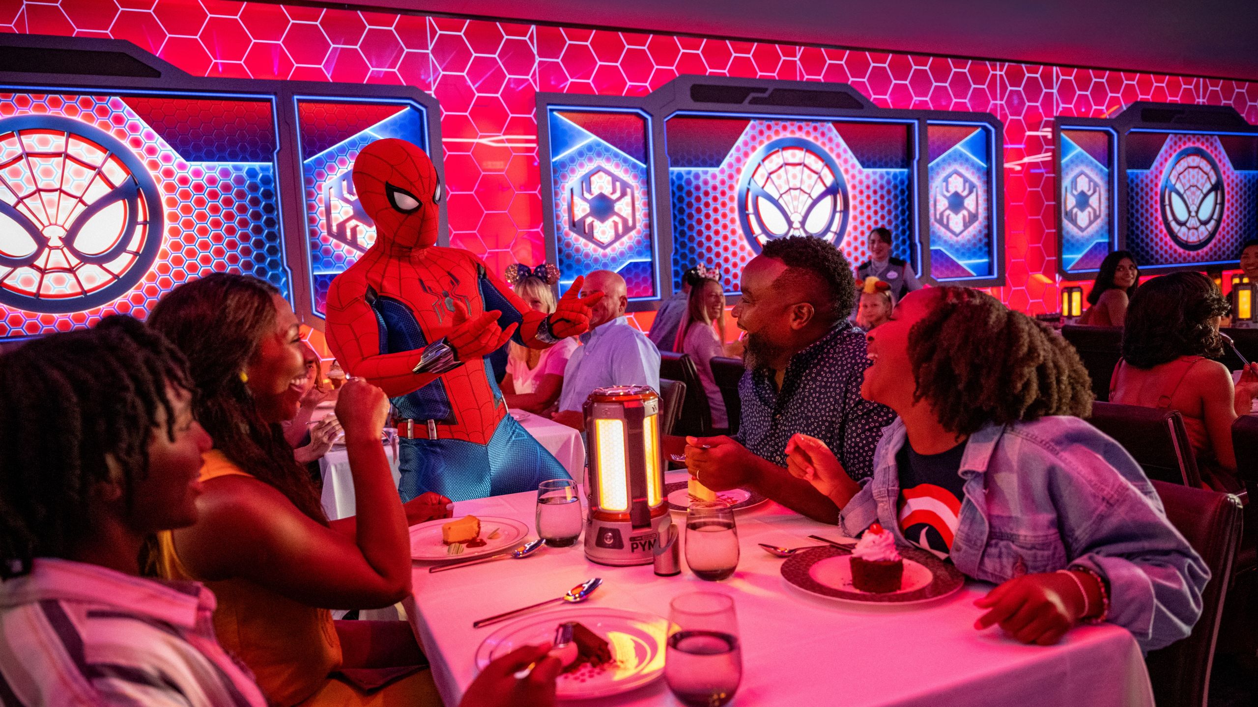A family laughing with Spider Man at Worlds of Marvel