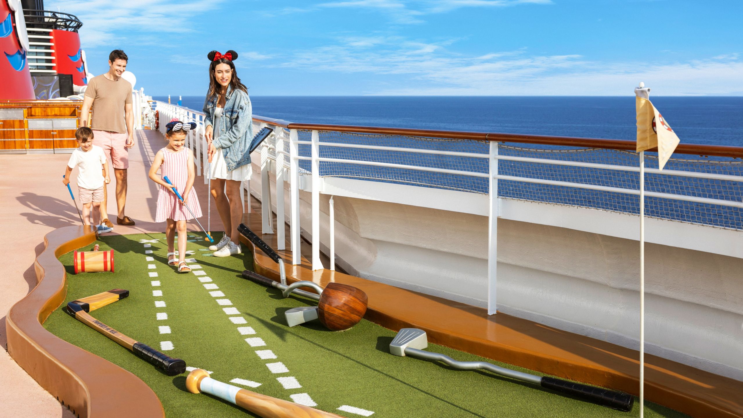 Una familia jugando al minigolf en la cubierta del Disney Dream